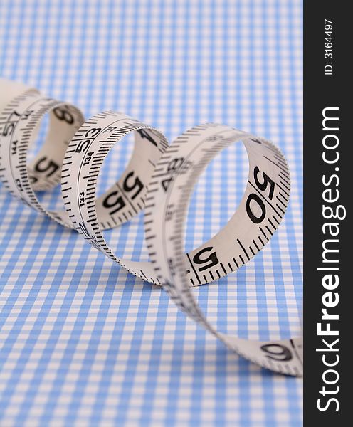 Sewing measuring tape on gingham background
