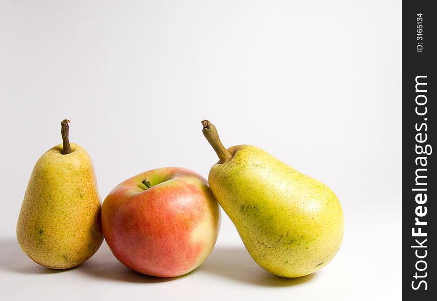 Two green pears and red apple on white  background. Two green pears and red apple on white  background.