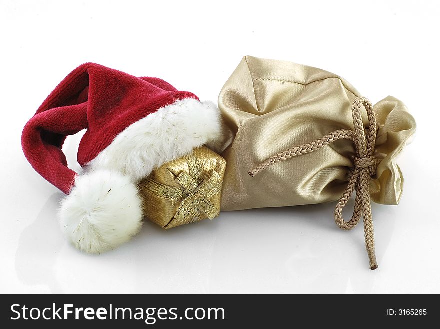 golden gift bag with gift and red santa claus hat. golden gift bag with gift and red santa claus hat