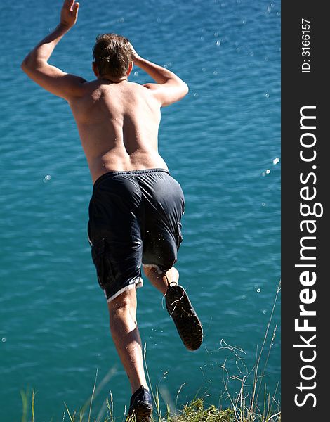 A young man jumps from a cliff into the sea, motion blur. A young man jumps from a cliff into the sea, motion blur