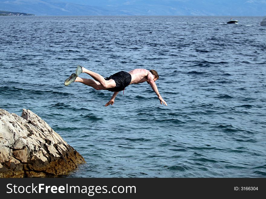 A young man jumps from a cliff into the sea!. A young man jumps from a cliff into the sea!