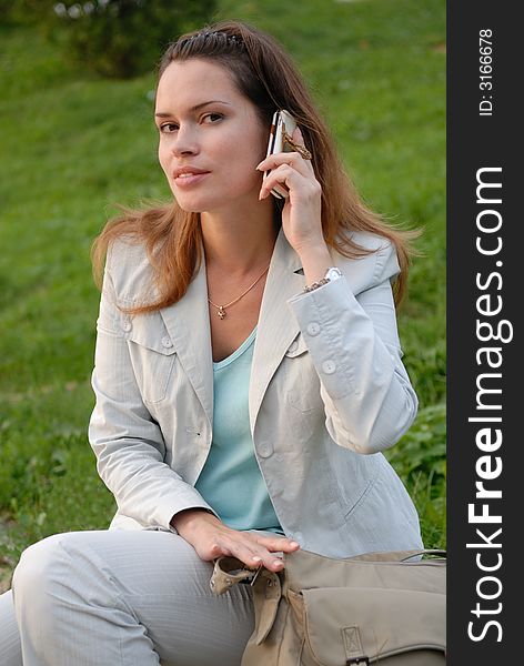 Beautiful woman talking by the mobile phone outdoors. Beautiful woman talking by the mobile phone outdoors