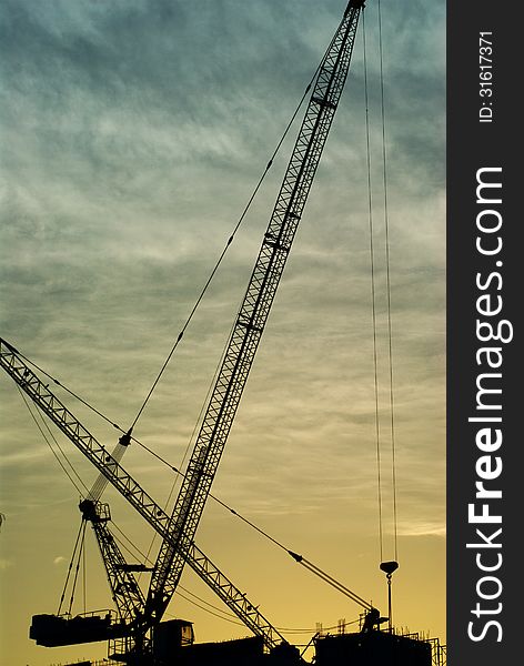Silhouette of the tower crane on the construction site