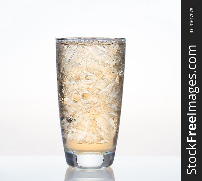 Sweet apple juice with ice in glass on white background