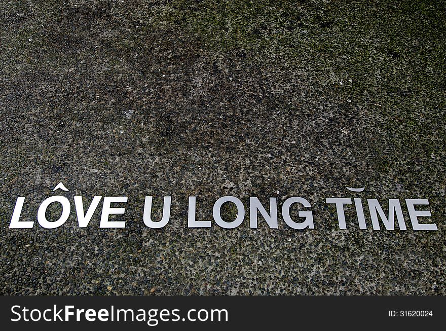 A Love you long time saying on a pavement.