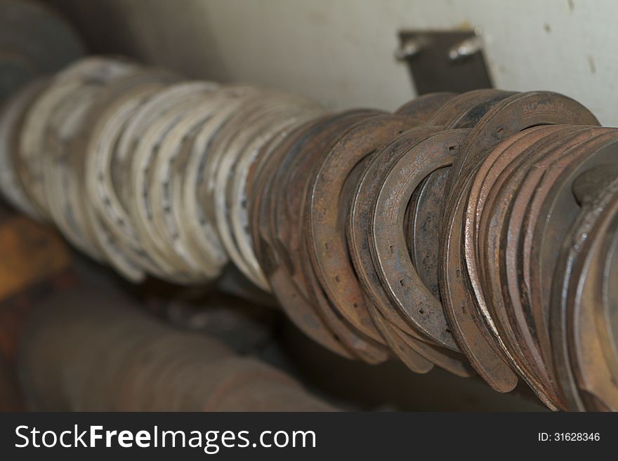 A row of various sizes of horseshoes hanging in the back of a farrier's trailer. A row of various sizes of horseshoes hanging in the back of a farrier's trailer.