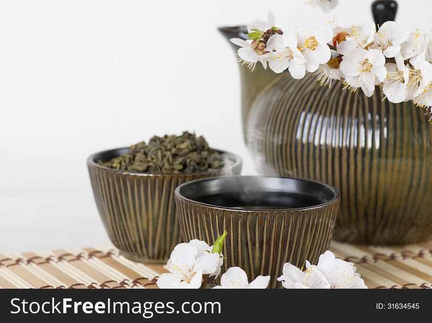 Teapot, cups and blooming cherry twig. Teapot, cups and blooming cherry twig