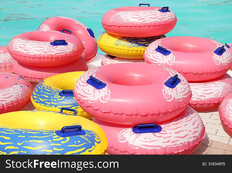 A lot of colorful inflatable swim rings by the swimming pool