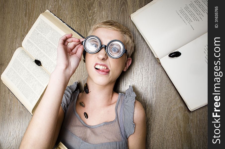 Portrait of crazy student in glasses with books and cockroaches