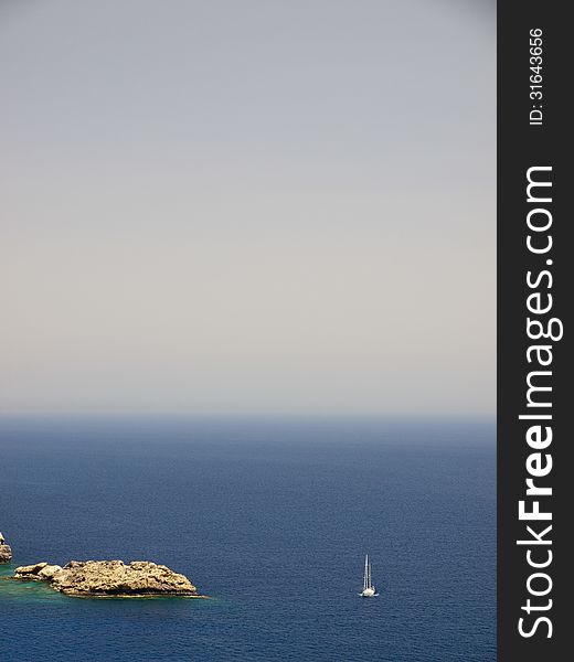 A sailing ship passes by in Lindos Bay, Lindos, Greece. A sailing ship passes by in Lindos Bay, Lindos, Greece