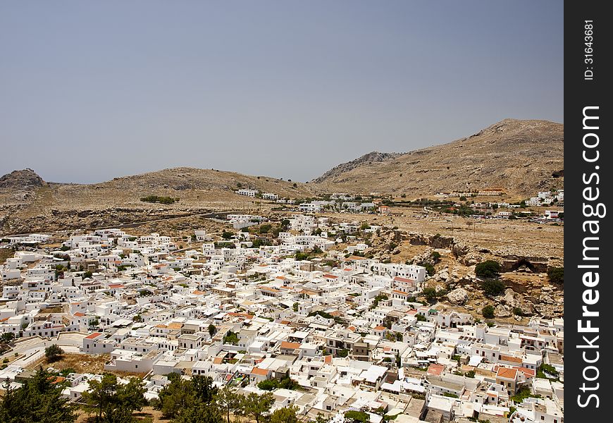 Lindos town, famously known for its white buildings, as seen from the top of the mountain, from the Lindos Acropolis.