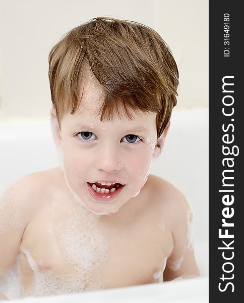 Cute three year old boy taking a bath with foam. This image has attached release.