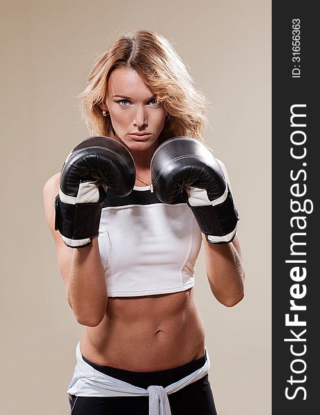 Portrait of blonde sportish woman in boxing gloves. Portrait of blonde sportish woman in boxing gloves