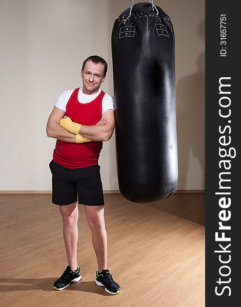 Man in boxing gloves makes a series of exercises punching bag. Man in boxing gloves makes a series of exercises punching bag