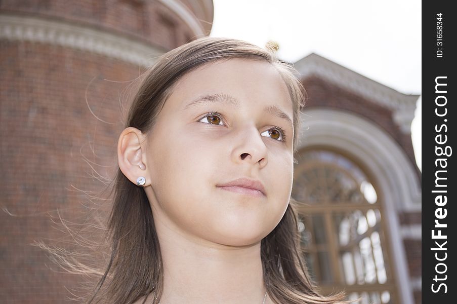 The brown-eyed European girl of 10 years is photographed against a cathedral. The brown-eyed European girl of 10 years is photographed against a cathedral.