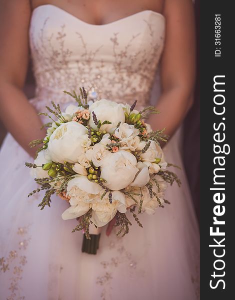 Wedding bouquet of flowers held by a bride. Pink, Orange, and Green