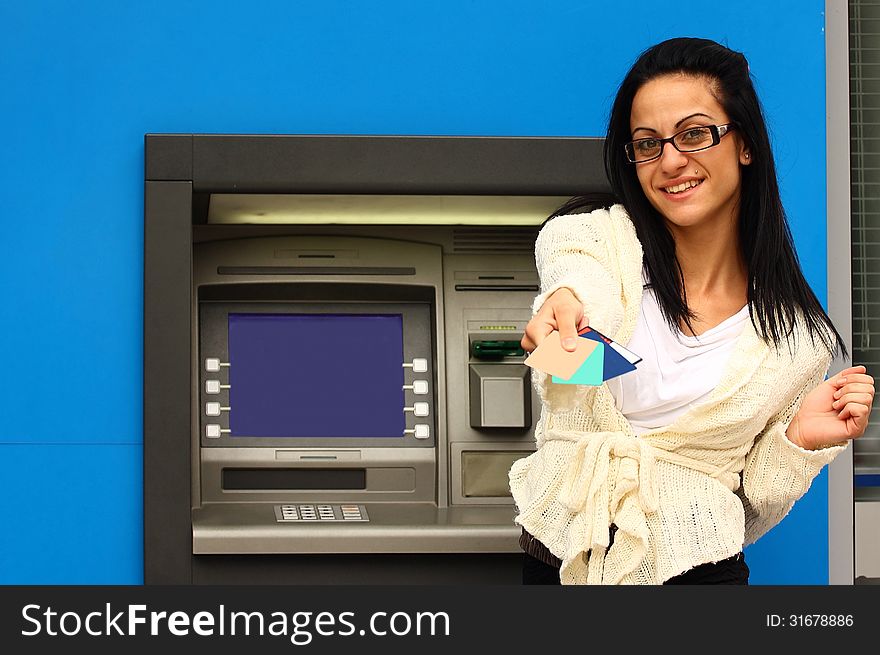 Woman in-front of atm machine offering credit cards. Woman in-front of atm machine offering credit cards