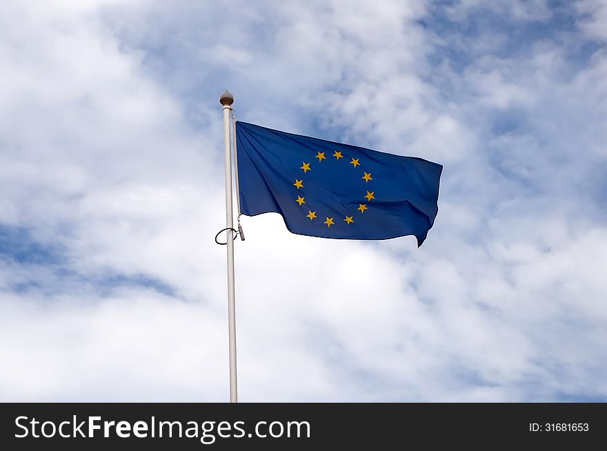 EU flag swaying in the background of the cloudy sky