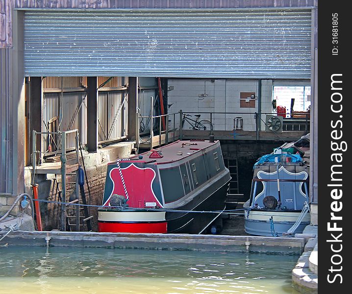 Two Canal Narrow Boats in Dry Dock for Maintenance. Two Canal Narrow Boats in Dry Dock for Maintenance.