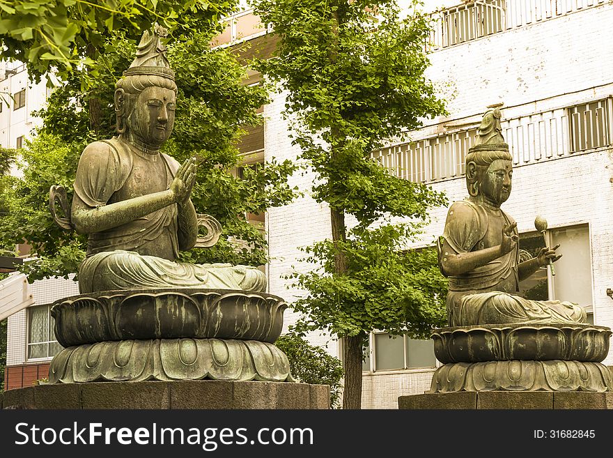 Japanese Buddha sculptures with residential buildings behind at Asakusa area in Tokyo. Japanese Buddha sculptures with residential buildings behind at Asakusa area in Tokyo