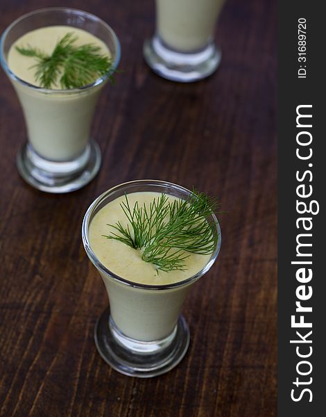 Zucchini Cream soup in glass with fresh herbs