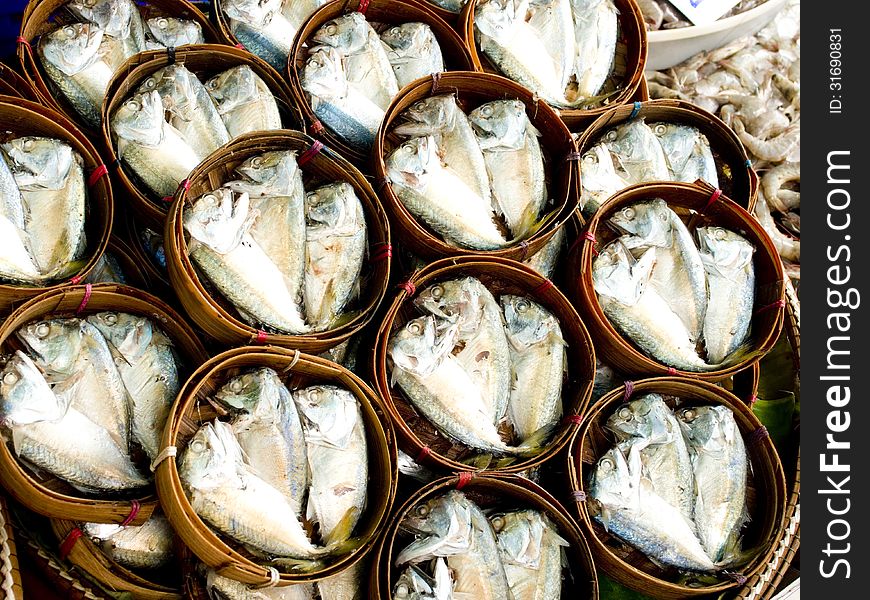 Short - bodied mackerels in round bamboo baskets.