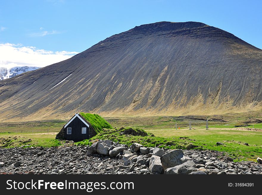 Icelandic turf house and mountains