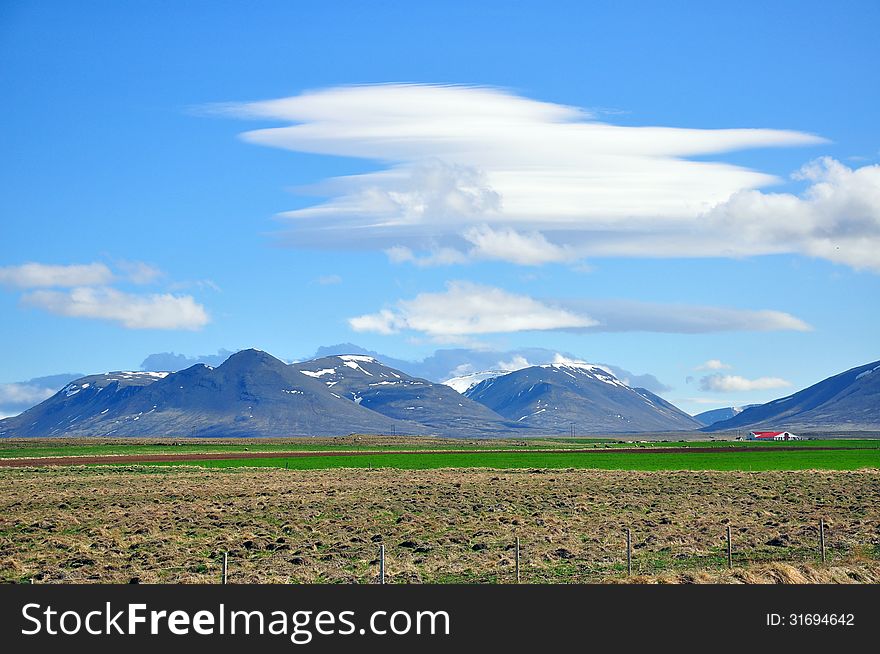 Amazing icelandic landscape: mountains, field, clouds