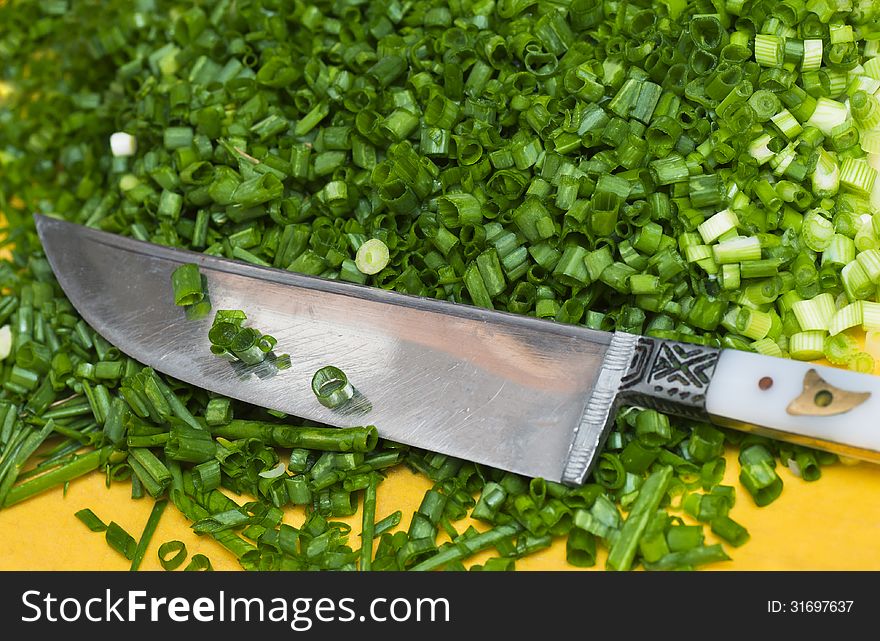 Chopped green onions cutting board with knife on the side. Chopped green onions cutting board with knife on the side