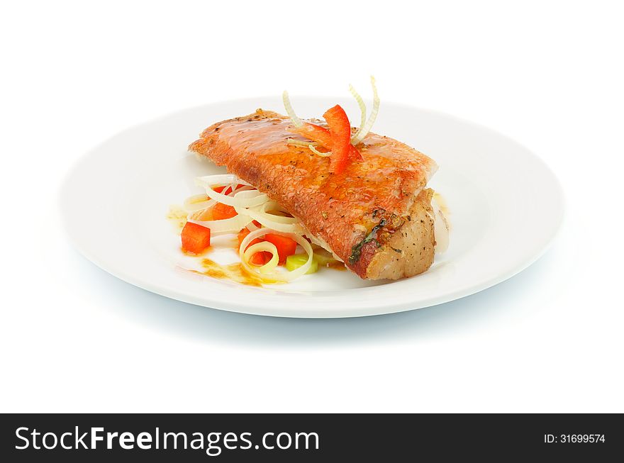 Delicious Roasted Red Snapper Fish Garnished with Red Bell Pepper and Leek Saute with Sauce on Plate  on white background