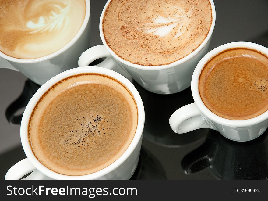 Four White Coffe Cups On The Black Background