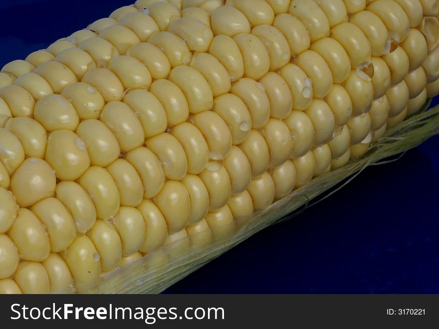 Isolated corncob with waterdrops on it. Isolated corncob with waterdrops on it.