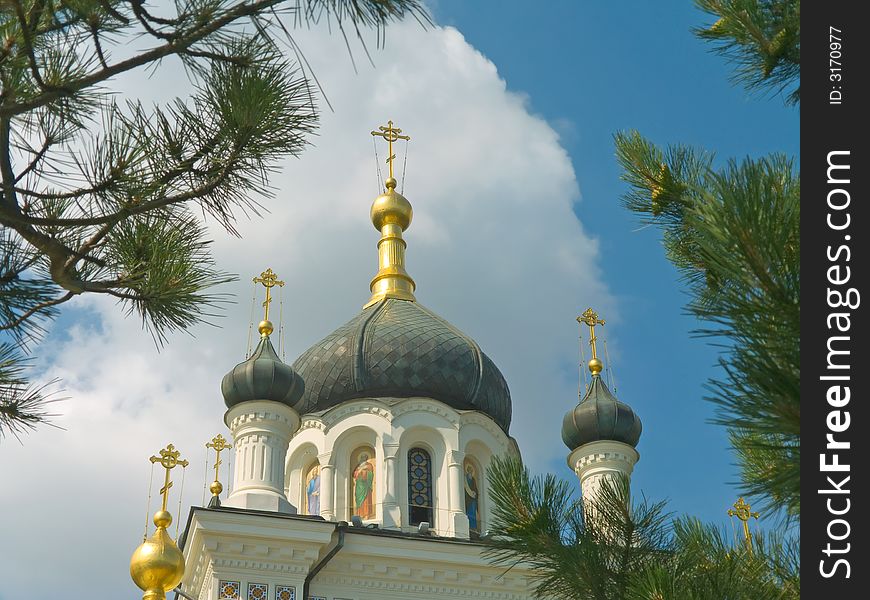 Gold crosses and domes of church, sky and trees