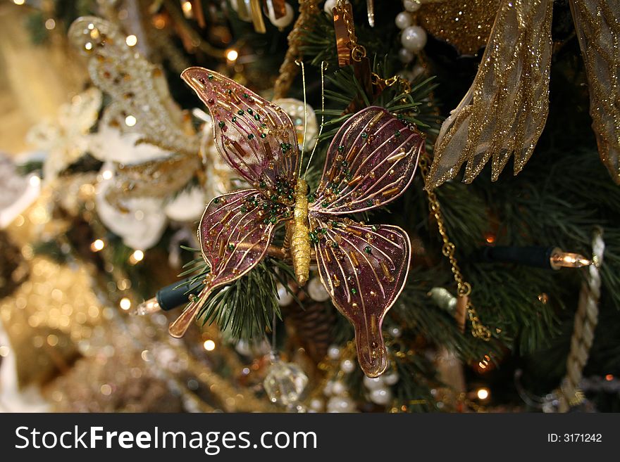 Christmas fur-tree decorated by the toy pink butterfly with balls