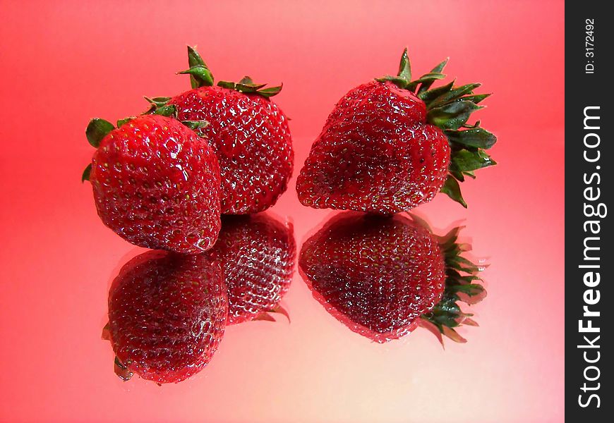 Three strawberries reflected on mirror. Three strawberries reflected on mirror.