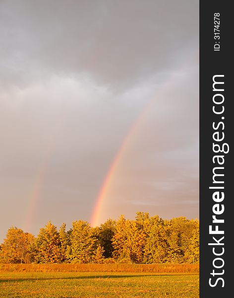 Double rainbow with a sunlit landscape