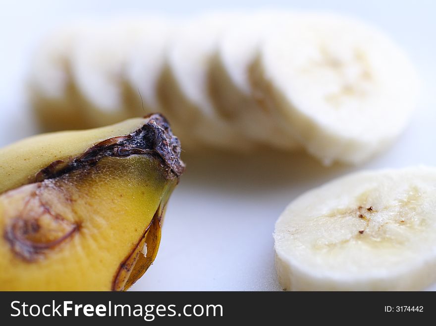 Sliced bananas with skin on white