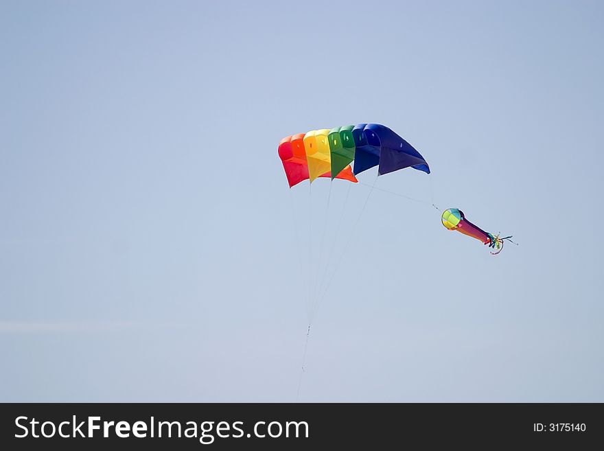 A multi-colored kite flying in the sky. A multi-colored kite flying in the sky