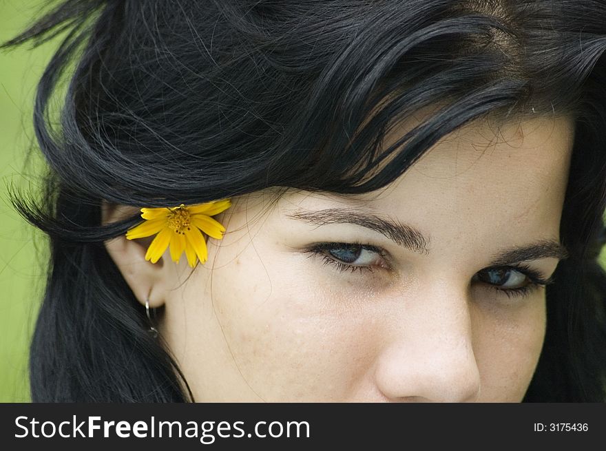 Eyes of a young beautiful brunette girl wearing a flower on hair. Eyes of a young beautiful brunette girl wearing a flower on hair