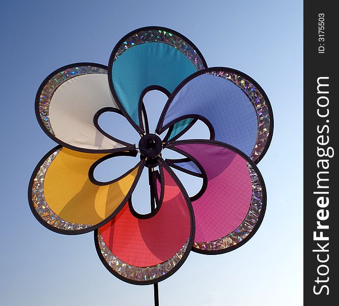 Multi colour wind turbine against blue sky