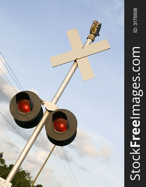 Railroad crossing sign under blue skies