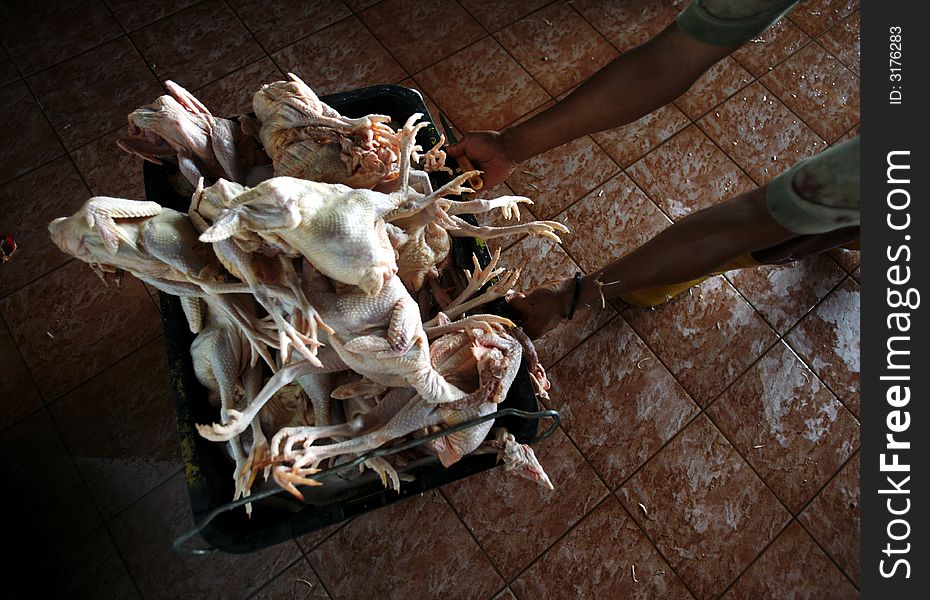 Chickens are kept in a basket for sale.