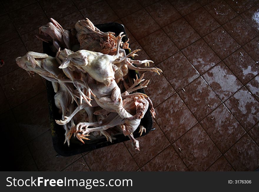 Chickens are kept in a basket for sale.