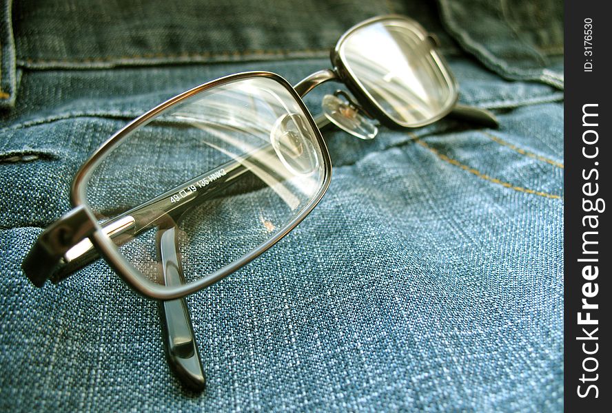 Glasses on a jeans surface. Glasses on a jeans surface