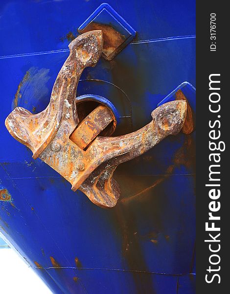 Dirty and rusty old anchor in blue ship