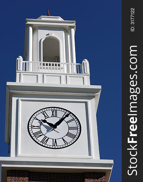Beautiful architectural clock tower set against deep blue summer sky.