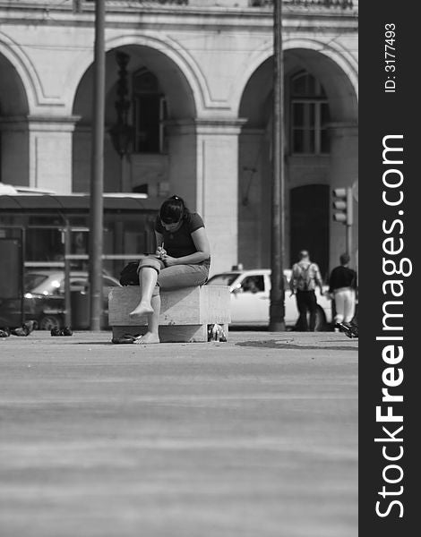 Black and white photo of a girl writhing in a square. Black and white photo of a girl writhing in a square