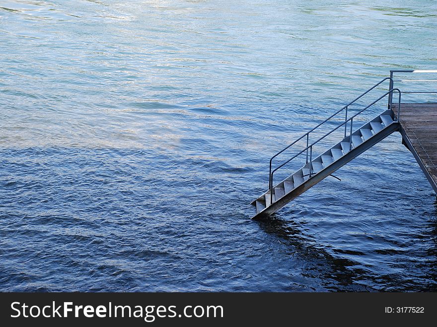 Stairs going into water from a wooden platform. Stairs going into water from a wooden platform