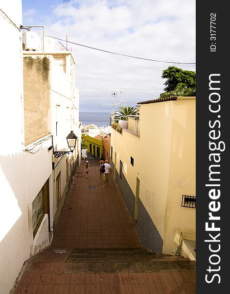 Narrow street with sky and see behind.