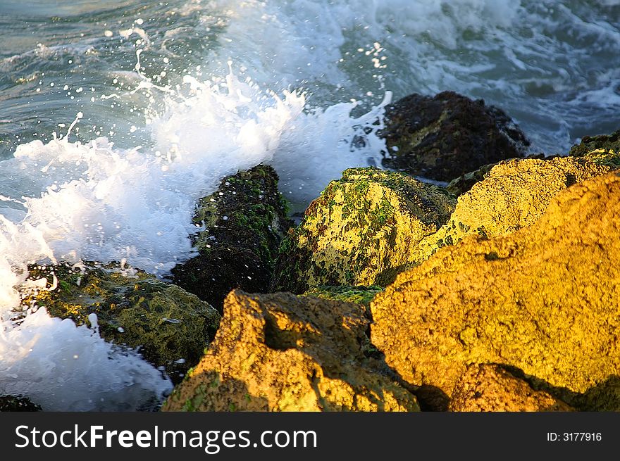 A photo of splashing sea water on beach stones. A photo of splashing sea water on beach stones